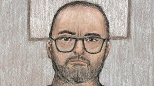 A court artist's drawing of Daniel Kinahan appearing by videolink from prison. He has short dark hair, a beard and moustache and glasses.