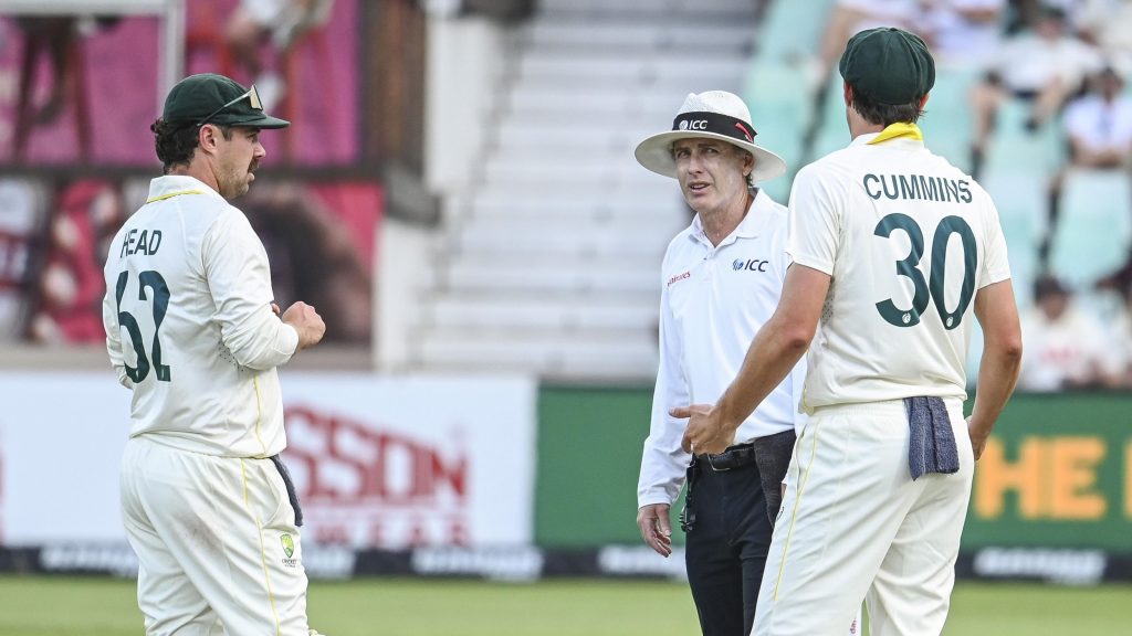 Australia captain Pat Cummins discusses conditions with umpire Chris Gaffaney