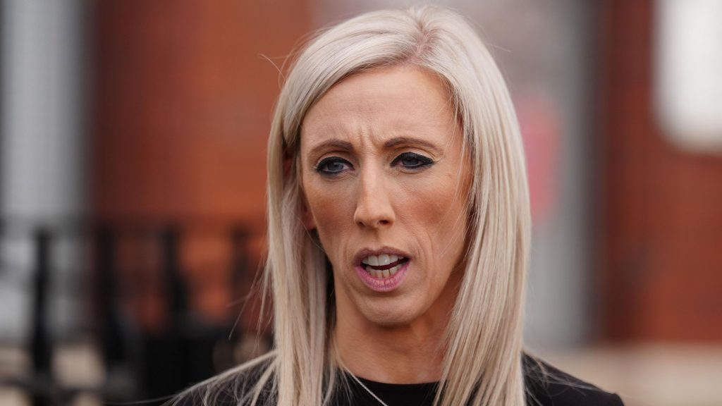 A woman with blonde hair wearing a black top